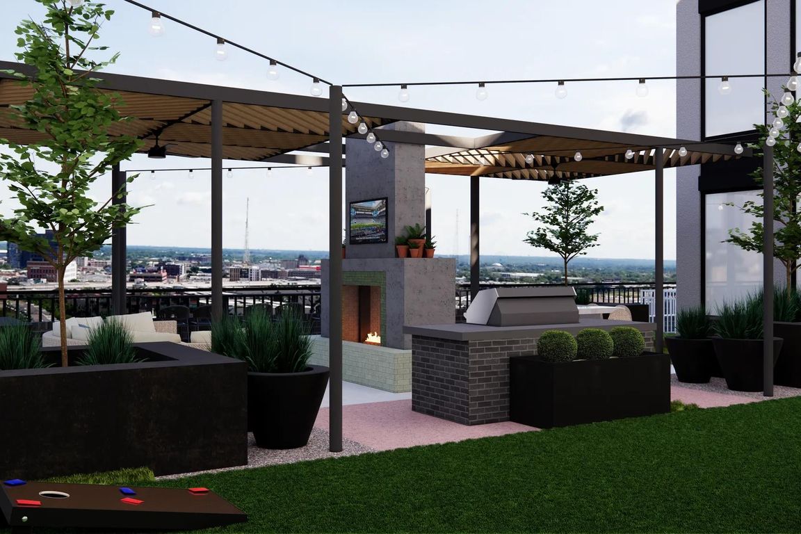 Garden terrace with grilling area, activity lawn, and fireplace with lounge seating .