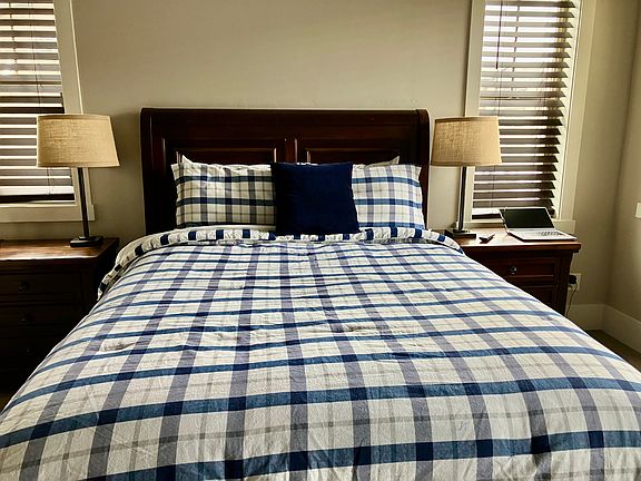 Primary bedroom with built in custom closet and storage drawers in queen size bed.