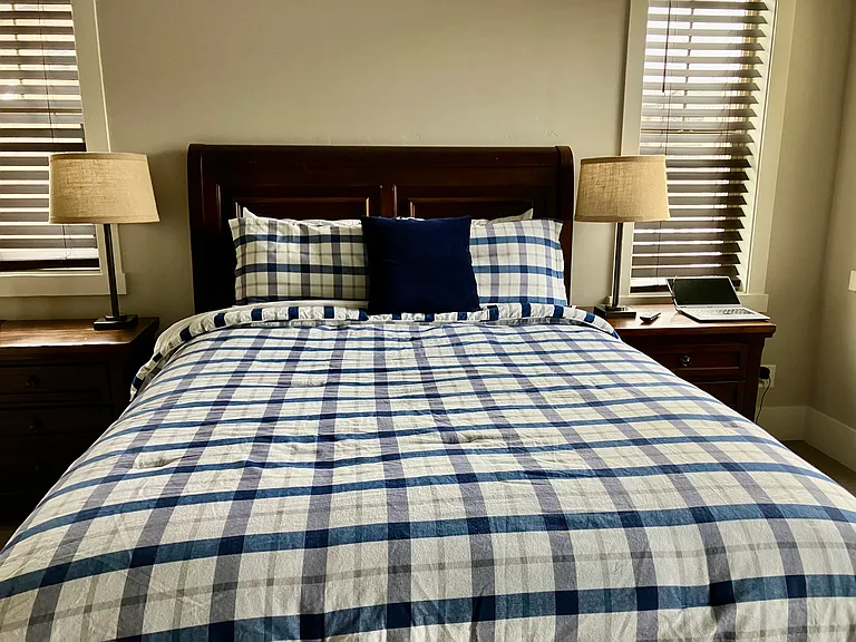 Primary bedroom with built in custom closet and storage drawers in queen size bed.