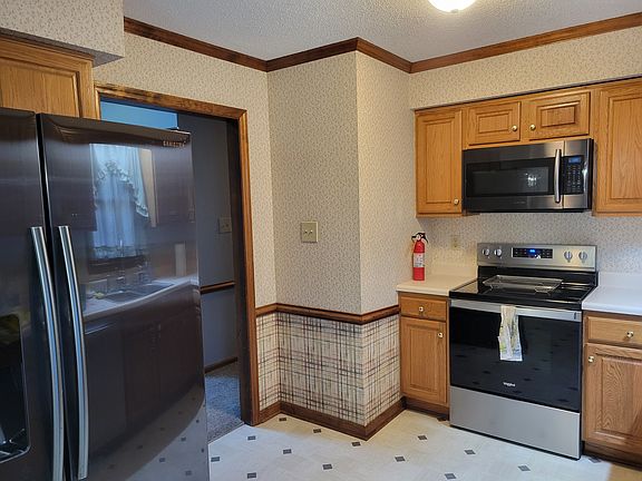 Kitchen Stove and Refrigerator. Vinyl flooring and wallpaper.