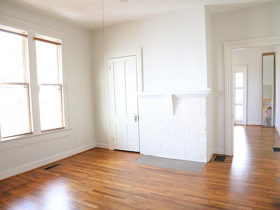 Bedroom features original flooring, doors, fireplace (non working) double paned windows & wooden Levelor blinds