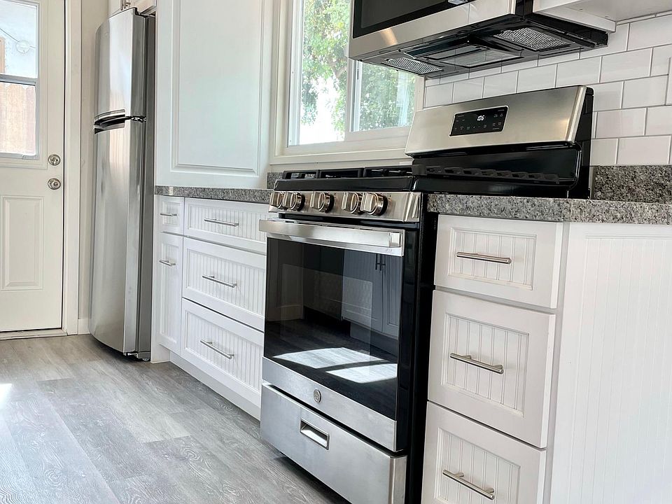 Kitchen custom shaker cabinets with new appliances, granite counters and tiled backsplash.