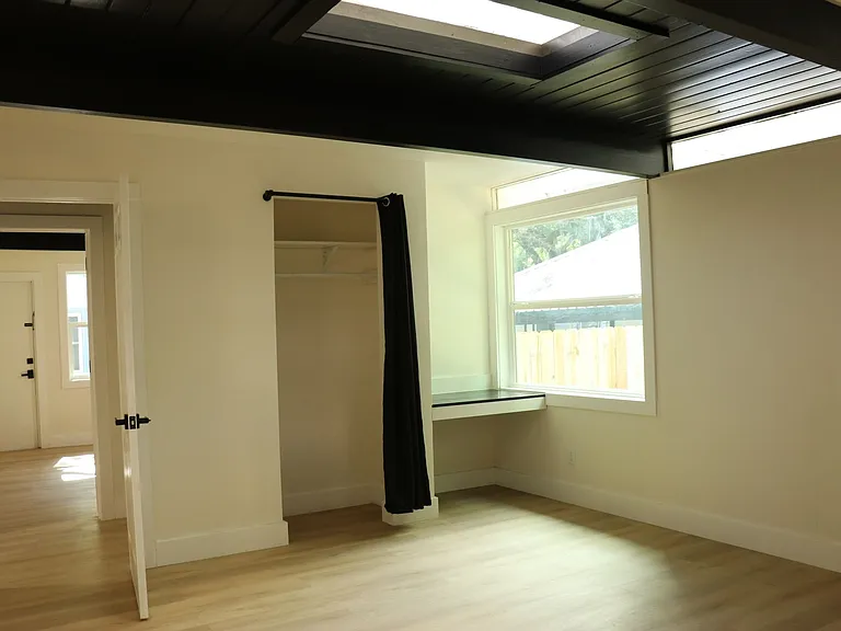 Generous-sized bedroom with large window and closet.