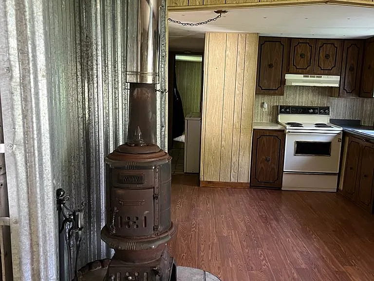 Kitchen (R), Hallway/Utility Room (L background) Leading to Master Bedroom & Fireplace. As seen from Living Room