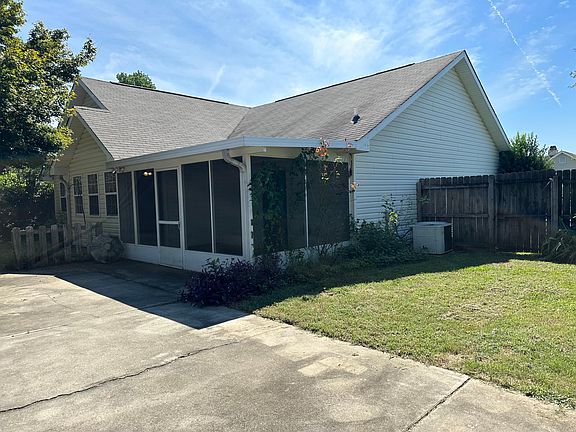 Florida room, fenced in backyard with concrete pad.