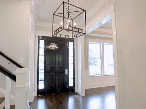 Double-height arrival, chandelier scaled to match