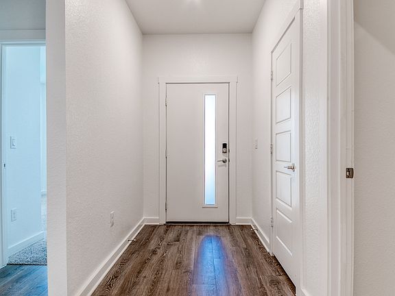 Front entrance hallway with bedroom pictured to the left.