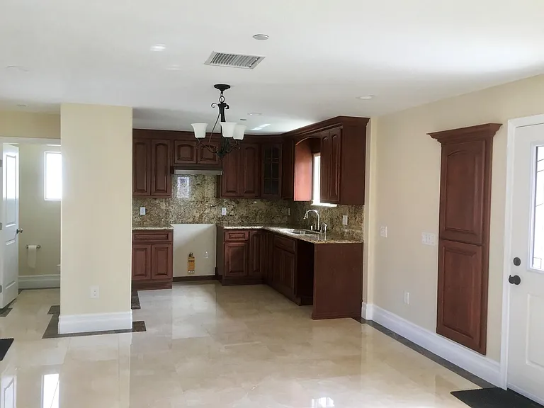 KITCHEN VIEW SHOWING HALL TO BATH AND PANTRY CABINET