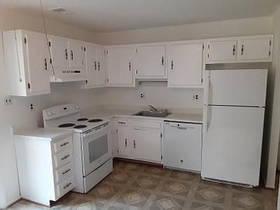 First floor kitchen with new dishwasher, electric stove, refrigerator and newly painted cabinets and cleaned and shined hardware