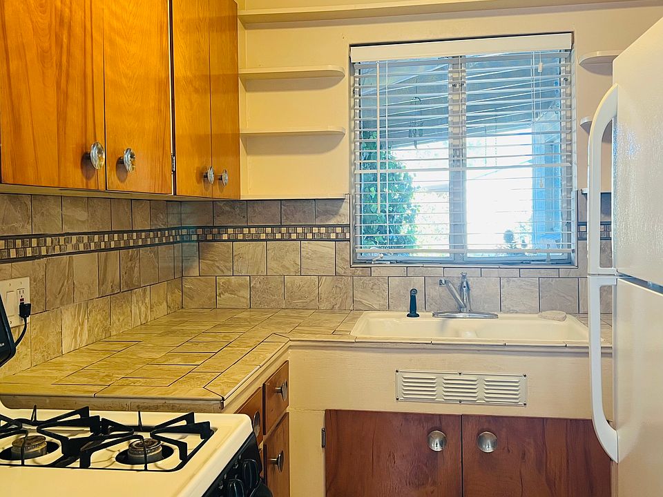Kitchen has four burner gas stove with electric oven. Window looking to porch.