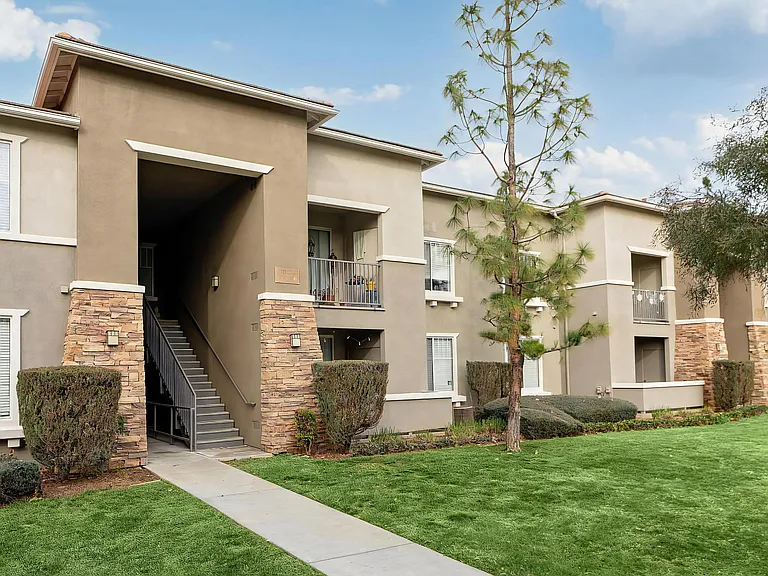 Camino Real Apartments Exterior with Clean Landscaping and Central Staircase