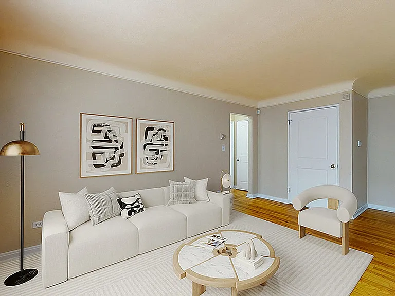 Elegant living room with a modern white sofa, stylish wooden flooring, and chic decor, perfect for cozy gatherings.