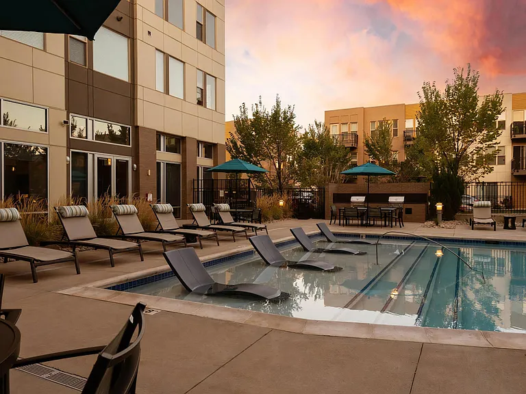 Evening Light Over Pool Area with Grills and Lounge Chairs