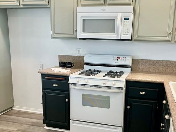 Cute kitchen with lots of cabinets, custom paint, gas stove