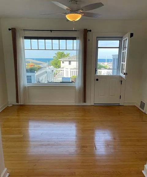 Living Room with amazing lake views and natural light, original maple floors, and a Dutch door leading to a private 8'x12' deck.