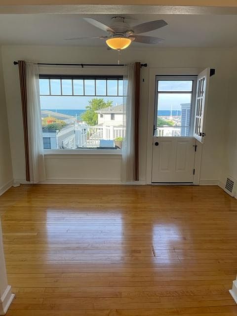 Living Room with amazing lake views and natural light, original maple floors, and a Dutch door leading to a private 8'x12' deck.
