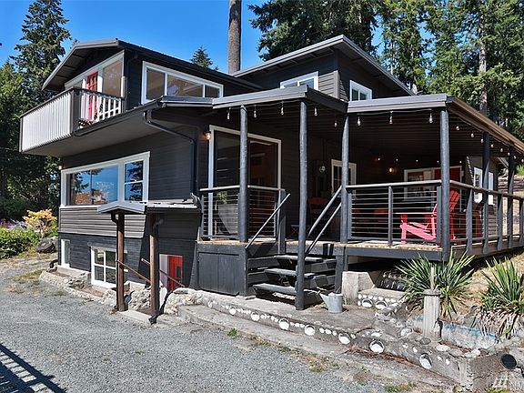 Notice the abalone shells shining their sea beauty, one of the many original features of this charming cabin. Red door on lower level leads to the basement level. Sliding glass doors off of deck lead into main living/kitchen of home. Balcony lives with the upper front bedroom.