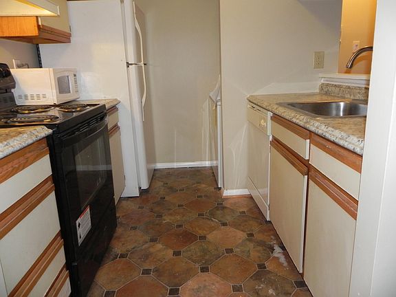 Galley kitchen includes stacked washer/dryer