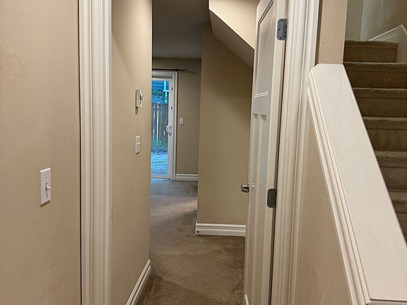 The first floor includes direct access to a one-car garage, a bedroom, full bath, and a stairway leading to the kitchen and living room.