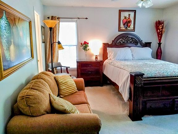 A queen sized bed with a new Roku "40" flat screen TV mounted on a mobile TV stand. Free Internet & Spectrum TV. The "Peace" bedroom also has a loveseat, nightstand, & large triple drawer dresser.
