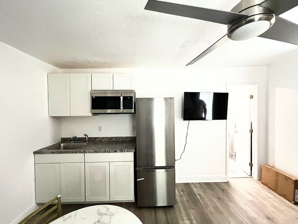 Kitchen with Fridge, cooktop, microwave and cabinet storage