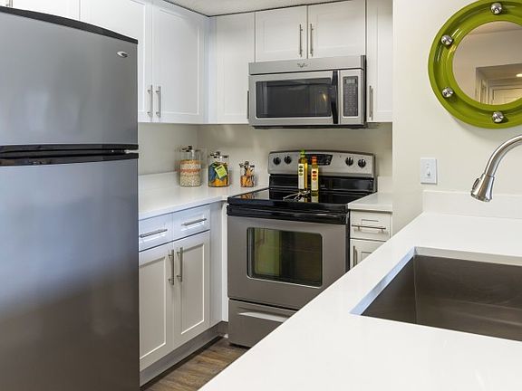Close up view of a luxury Palm Beach Florida apartment kitchen with white wood cabinetry.