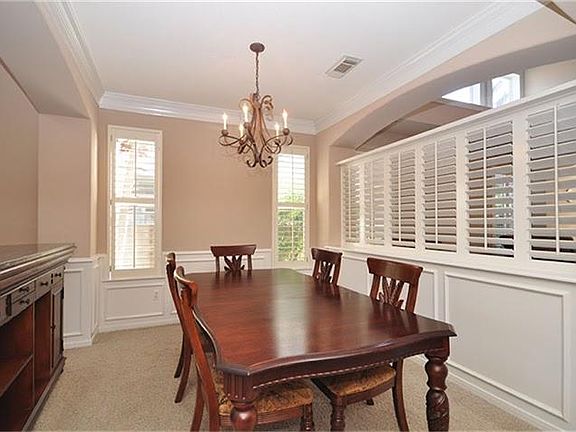 Check out this unique formal living room. Plantation shutters, crown molding, wainscot with picture 