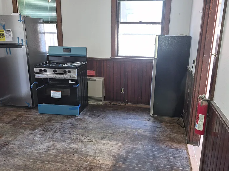 Old Hardwood Floors being professionally restored and refinished this week. (Appliances in backround installed this week). Ready for rent Sept 1st
