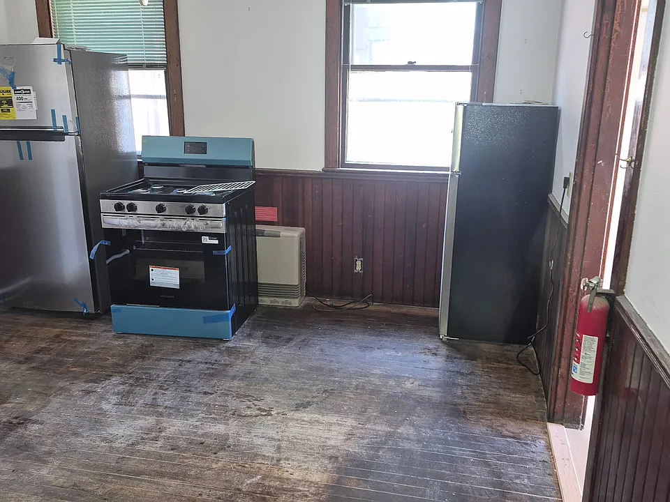 Old Hardwood Floors being professionally restored and refinished this week. (Appliances in backround installed this week). Ready for rent Sept 1st