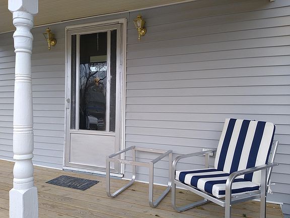 Front porch with patio furniture and end table with dusk/dawn automatic lights.