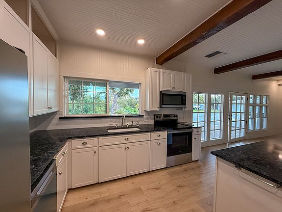 Granite countertops with extensive space and new laminate floor and exposed beams