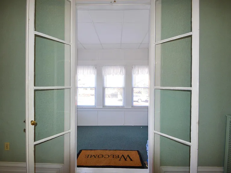 Looking from the living room to the front porch - the living room has been painted to a soft beige