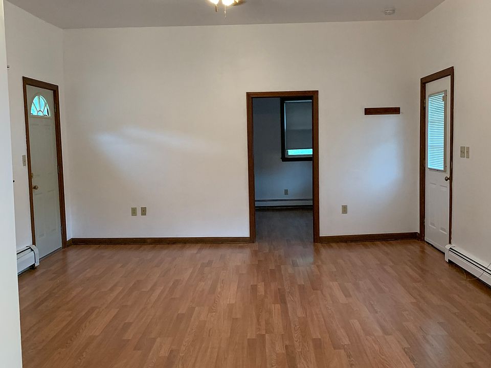 Living room, facing larger bedroom. Front & rear entrance to either side.