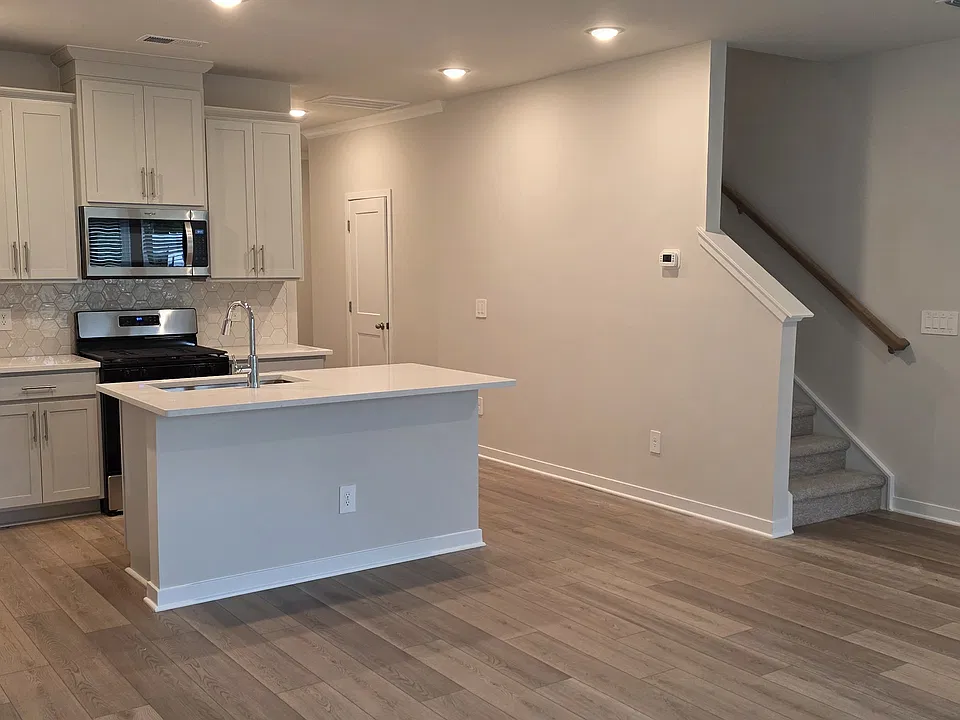 Stairs to upstairs with a half bath under the stairs.