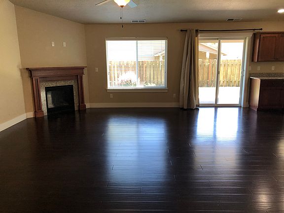 Great Room with gas fireplace, vaulted ceiling, and wood look laminate flooring.