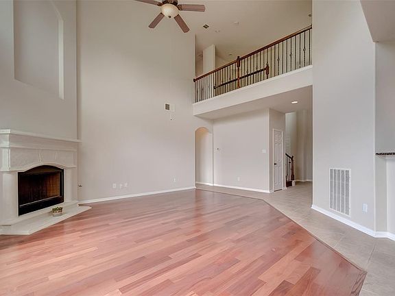 Light-filled 2-story open living area with fireplace, adjacent to island kitchen and casual dining space.