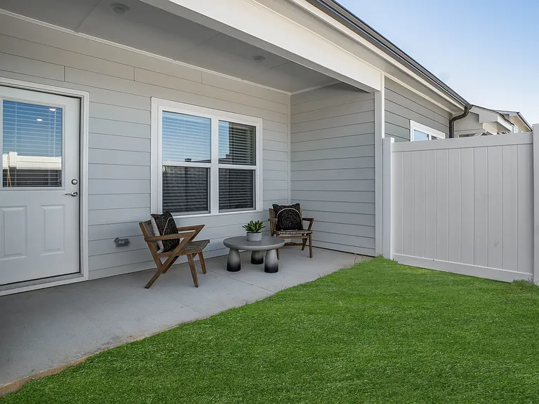 Covered back patio with fenced in yard.