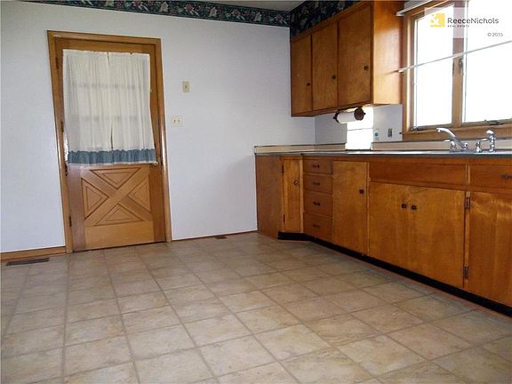 Kitchen showing new interlocking vinyl tile flooring and door to garage.