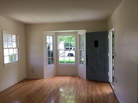 Living room. Gorgeous floor, window, and door! Don't you love the historic charm?