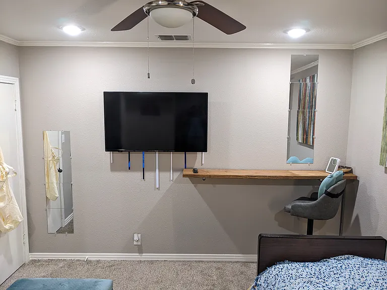 The wall opposite the Murphy Bed features a versatile bar that can function as a desk or vanity. The room comfortably accommodates a Queen-size bed. Here an extra twin-size bed is positioned parallel to the Murphy Bed.