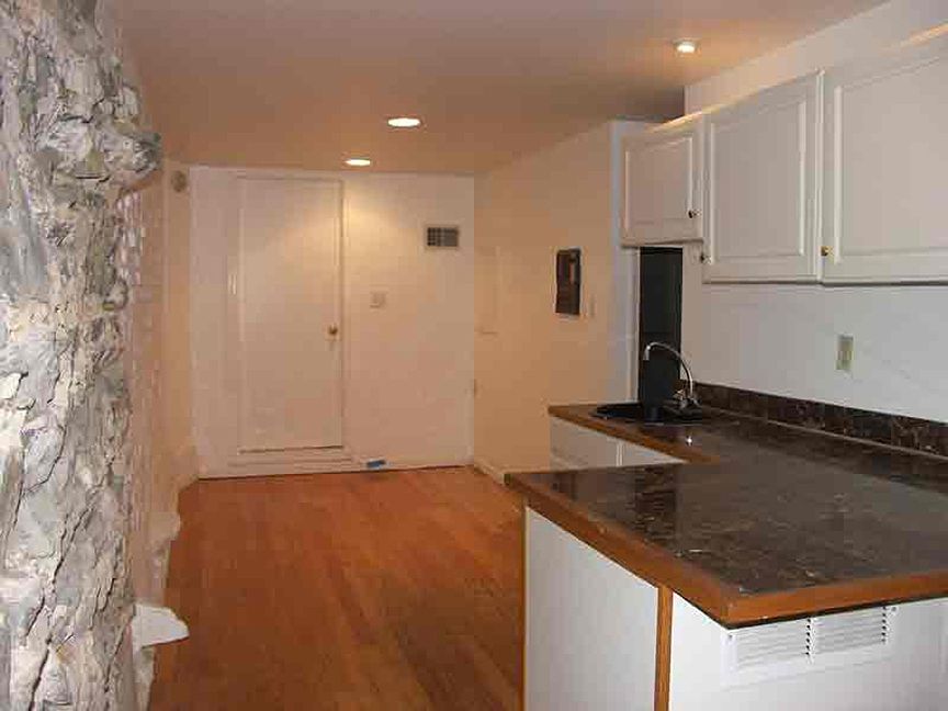 Kitchenette and separate space beyond. Closed door leads to the bedroom.