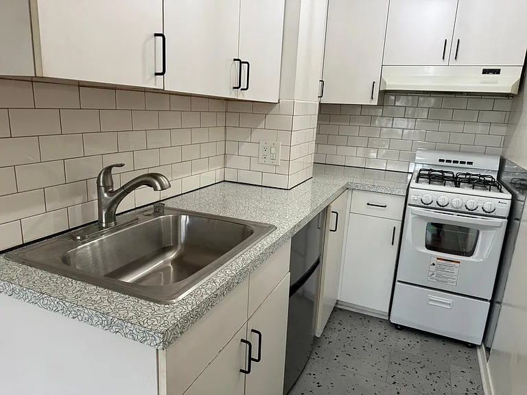 Updated kitchen with new laminate retro countertop, subway tile throughout, new kitchen sink and garbage disposal, new 4-burner gas stove, and new tile flooring.