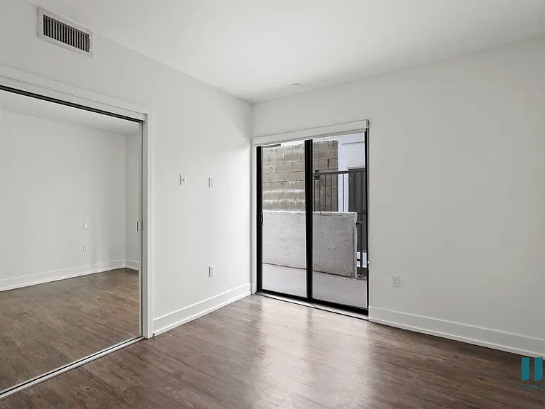 Bedroom with Balcony Access and Mirrored Closet