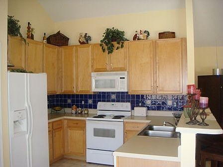 Kitchen has 42" cabinets, tile backsplash, microhood, breakfast bar.