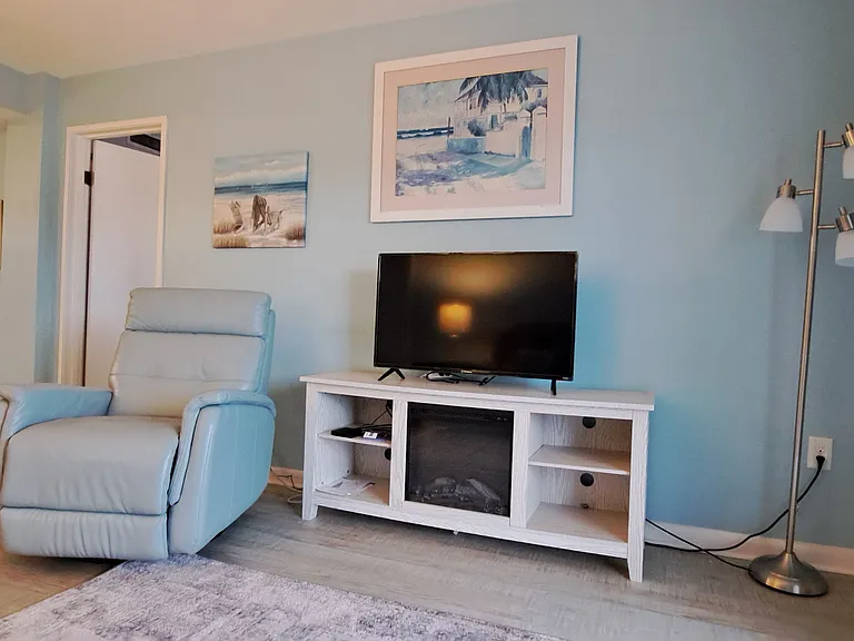Living room with entertainment center, 40 inch flat screen TV, leather swivel and recliner. Living room separates two bedrooms that are identical in size.