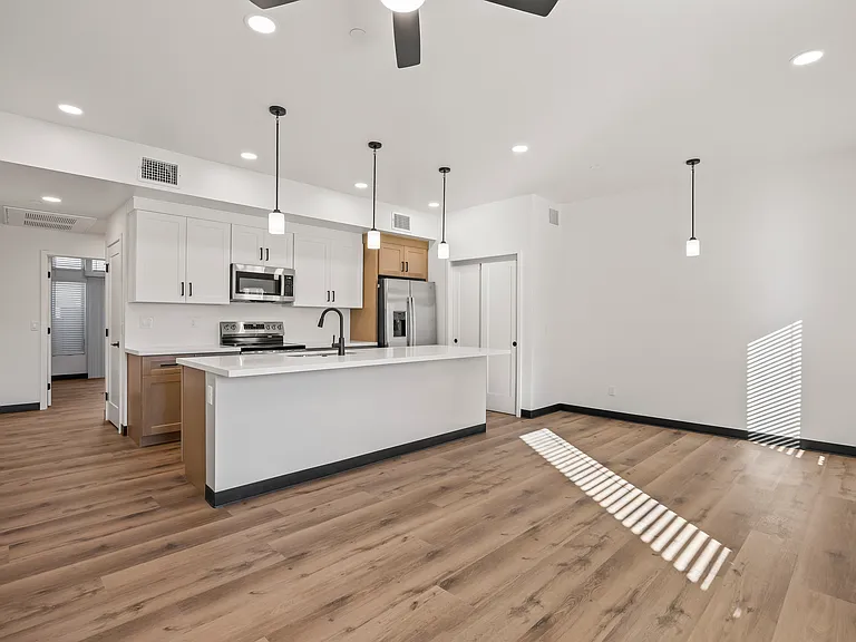 Open concept living with bar stool seating and stainless fingerprintless appliances