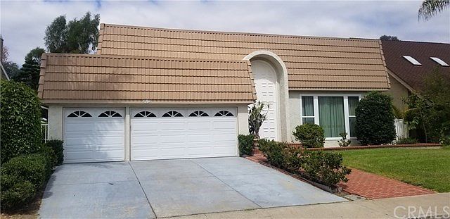 Front of house with 3 car garage and manicured landscape