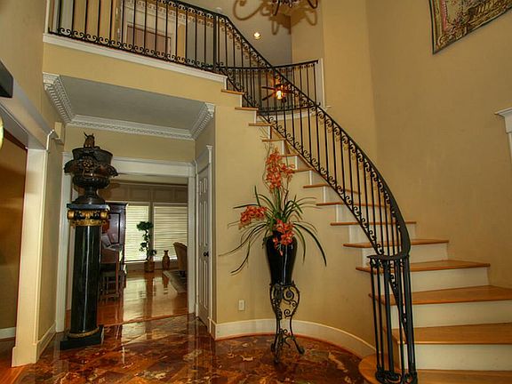 Grand two story entry with gorgeous onyx floors, custom wood staircase with wrought iron banister.