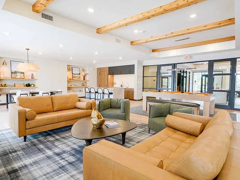 Immerse yourself in the upscale ambiance of our clubroom, where entertainment meets refinement with a pool table, modern kitchen, and chic seating areas.