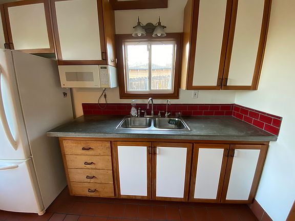 Kitchen with microwave, new water filter, cement countertops, gas stove.